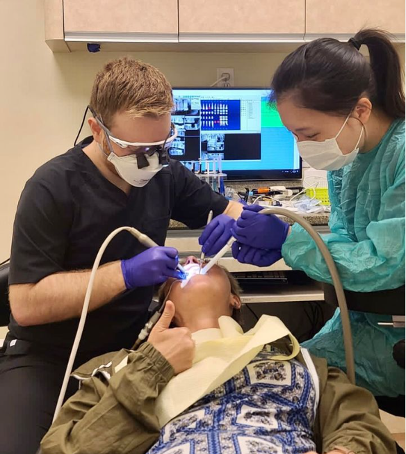 two dental staff members performing an exam